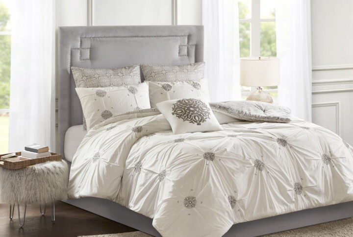 Style your bedroom with the shabby chic allure of the Madison Park Malia 6 Piece Embroidered Cotton Reversible Comforter Set. The face of the reversible comforter features tufted grey embroidery on an ivory base