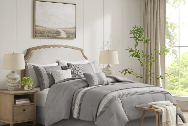 This 7 piece comforter set featuring white lace trimming and pintucks on a simple neutral ground is the perfect additional to any farmhouse or transitional bedroom. Also included are three decorative pillows featuring different techniques like pintuck