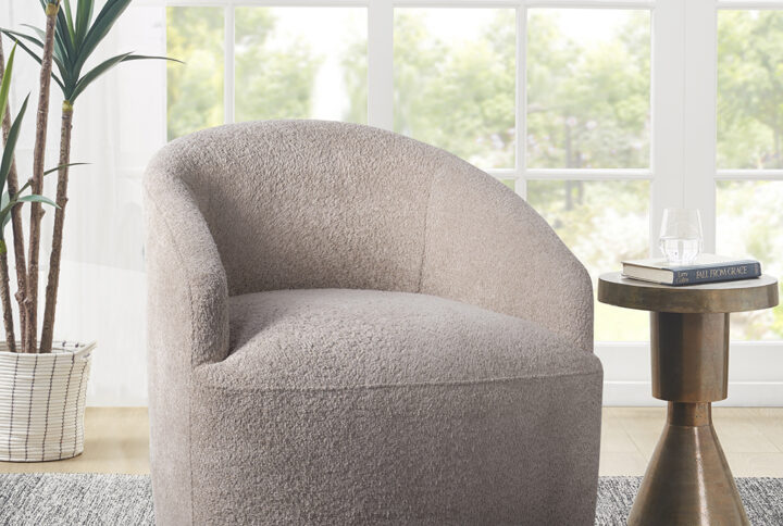 Add a comfortable and casual flair to your home with this swivel chair. This barrel-style chair is upholstered in a soft textured boucle fabric and has a tight attached seat to create a modern minimalist look. The sloped arms provide additional comfort to make this motion chair stylish and cozy. A hidden swivel base helps maintain the clean and seamless silhouette