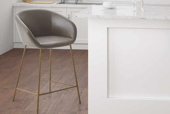 Elevate the look of your kitchen or dining room with the Madison Park Isadora Counter Stool. The low seat and back are upholstered in brown polyurethane leather and the slender metal base flaunts a gold finish