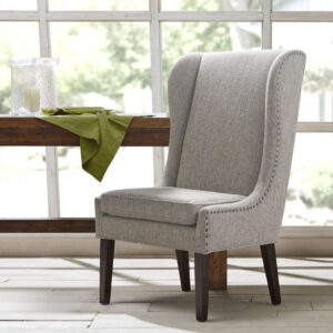 Complete your dining room decor with the Madison Park Garbo Captains Dining Chair. This chair features a high wing back design that will leave a monument impression for your guests.  Upholstered in a heather grey fabric and elevated with bronze nail head accents. The frame is supported on solid wood legs in a dark espresso wood finish.  Removable cushions