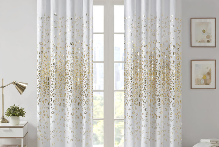 Add a touch of glam to your room with the Intelligent Design Lillie Grommet Top Metallic Animal Printed Total Blackout Curtain. A gold metallic animal print shines on the ultra-soft brushed white microfiber fabric to create a fun and glam modern look; while the 2 Pass foamback total blackout liner provides a thermal energy efficient barrier that helps block any exterior light and noise intrusion