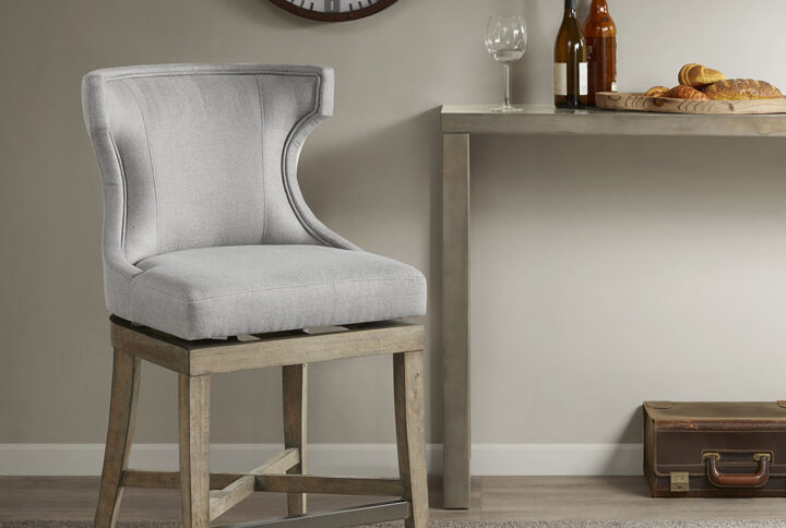 Define your dining area with the elegance of the Madison Park Carson Counter Stool with Swivel Seat. This pholstered wingback style counter chair features clean lines and curve