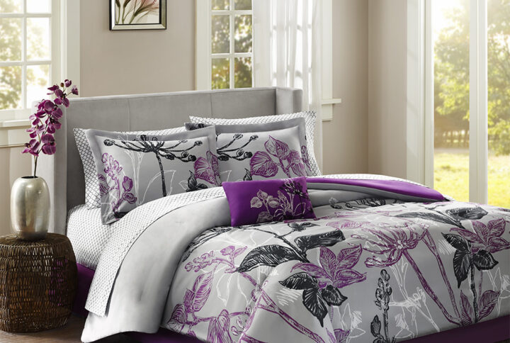 Make a bold fashion statement in your bedroom with the Madison Park Essentials Claremont Comforter Set with Cotton Sheet Set. A large scale bright purple and black floral print covers the grey comforter