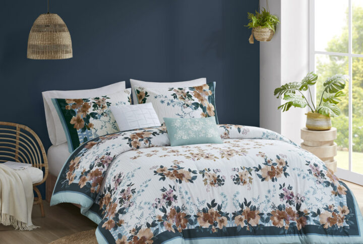 This shabby chic cotton comforter set features a floral print design on top of light grey vertical stripes with additional teal colored borders and blue lines creating a fenced look on the edges. Included in this set are also two decorative pillows with pleated and embroidery floral for a touch of elegance and refinement. Colors found in this bed set include various shades of teal