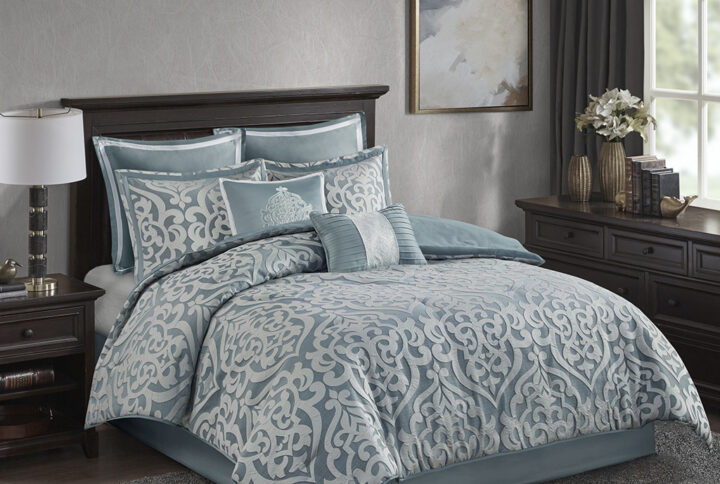 Add a touch of class to your bedroom with the Madison Park Odette 8 Piece Jacquard Comforter Set. The luxurious textured jacquard comforter and shams flaunt a gorgeous damask medallion design with silver striations on the satin ground that add dimension to the lavish look. A solid aqua reverse and stunning euro shams complement the top of the bed to complete the ensemble. Also included are two decorative pillows that feature embroidery and cording details