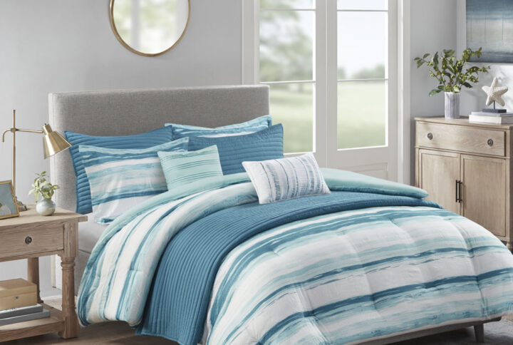 Create a relaxing and tranquil atmosphere in your bedroom with Madison Park’s Marina 8 Piece Printed Seersucker Comforter and Quilt Set Collection. The textured seersucker comforter features a watercolor stripe print in storm blue