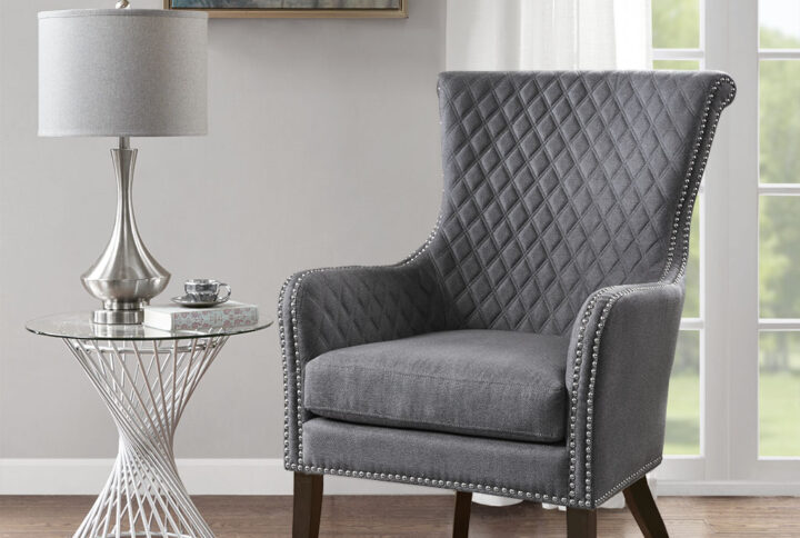 Relax in the luxurious style of the Madison Park Accent Chair. This modern accent chair takes on a classic twist with a quilted back and elegant silver studs lining the arms and seat. A high-density foam cushion fills the seat for exceptional comfort