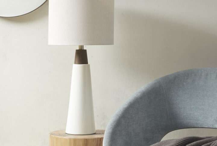 The INK+IVY Tristan Triangular Ceramic and Wood Table Lamp provides a refined addition to your home decor. Showcasing a two-tone conical stand