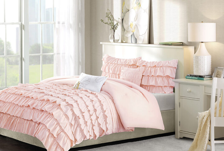 The Intelligent Design Waterfall Ruffled Comforter Set offers a graceful comfort to your bedroom decor. Beautiful flowing ruffles on the bottom half of the blush comforter add charming appeal to the comforter and 2 coordinating shams (1 for Twin/TwinXL). A solid blush reverse creates a clean look