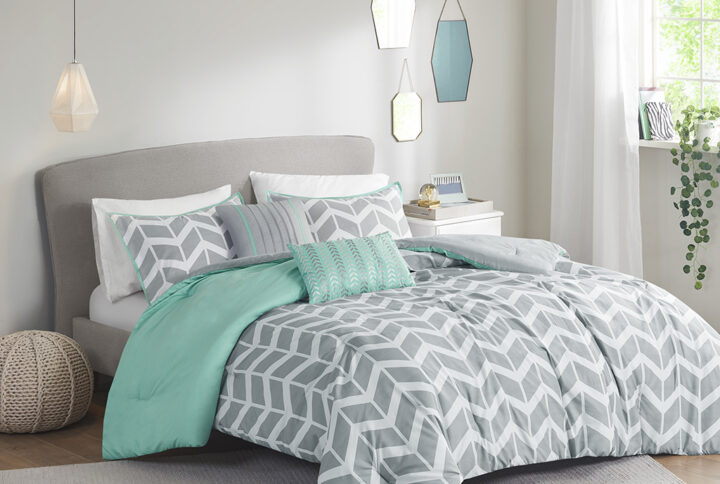 The Intelligent Design Nadia Comforter Set updates any bedroom into fun and inviting space. This stylish comforter features a grey and white chevron print broken up by white vertical stripes and a solid aqua at the top that pops! The 2 matching shams (1 in Twin/TwinXL) with an aqua flange pairs perfectly with the delightful chevron pattern