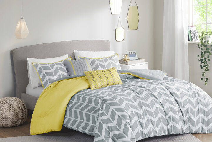 The Intelligent Design Nadia Comforter Set updates any bedroom into fun and inviting space. This stylish comforter features a grey and white chevron print broken up by white vertical stripes and a solid yellow at the top that pops! The 2 matching shams (1 in Twin/TwinXL) with a yellow flange pairs perfectly with the delightful chevron pattern