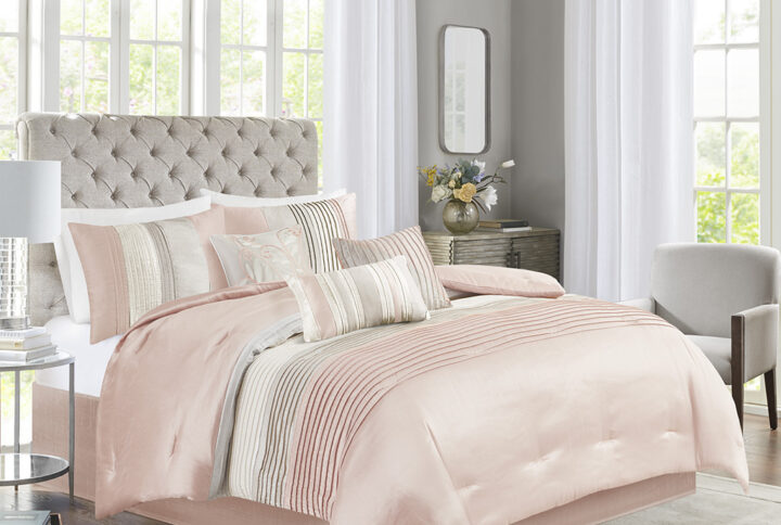 The Madison Park Amherst 7 Piece Comforter Set offers a beautiful update to your bedroom décor. The polyester faux silk comforter and shams features a pieced and pintucked design in blush