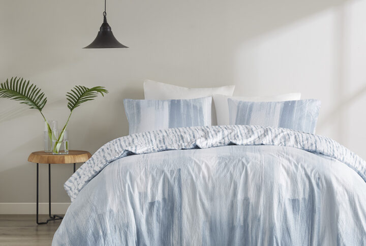 The N Natori Brush Stroke 3 Piece Reversible Seersucker Duvet Cover Mini Set elevates your bedroom with its simple and elegant lounge style. This reversible duvet cover flaunts a soft blue