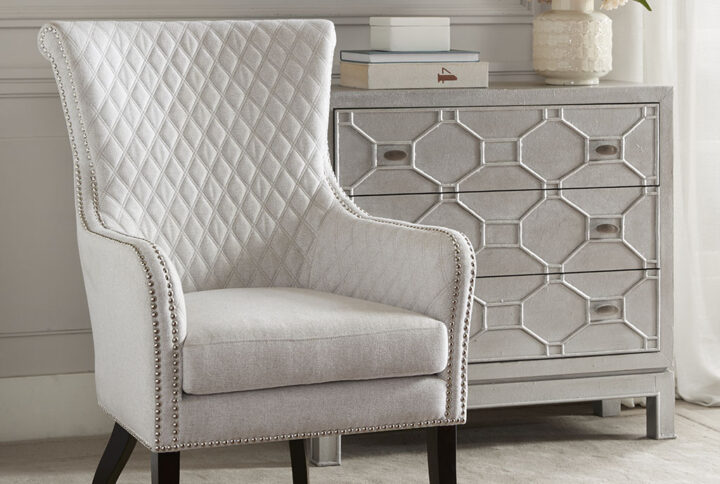 Relax in the luxurious style of the Madison Park Heston Accent Chair. This modern accent chair takes on a classic twist with a quilted back and elegant silver studs lining the arms and seat. A high-density foam cushion fills the seat for exceptional comfort