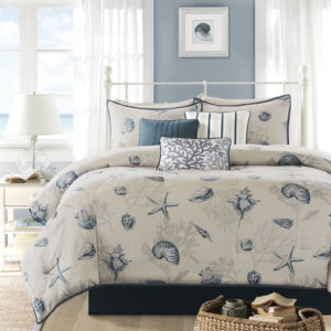 the comforter and shams feature assorted seashells accentuated with light and dark blue coloring on an ivory baackground. In a deep taupe color