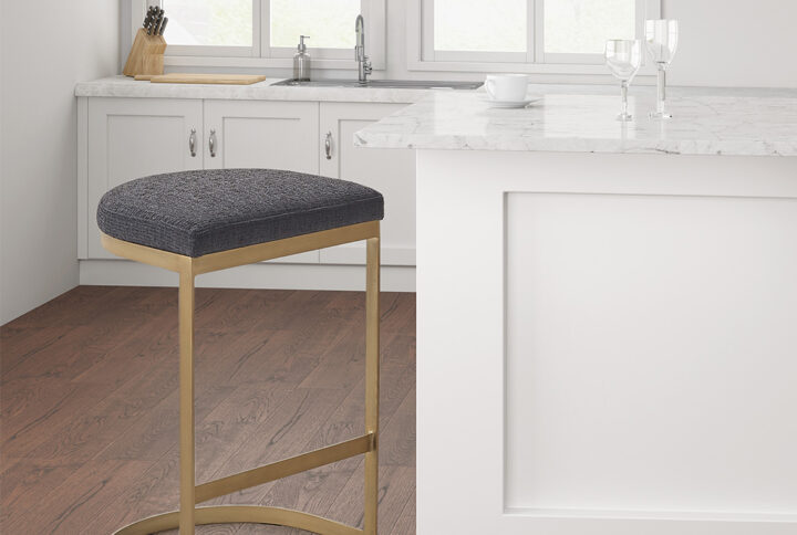 The Madison Park Maison Counter Stool offers a bold and modern update for your kitchen or dining room. This backless counter stool features a charcoal upholstered seat with an antique gold metal base