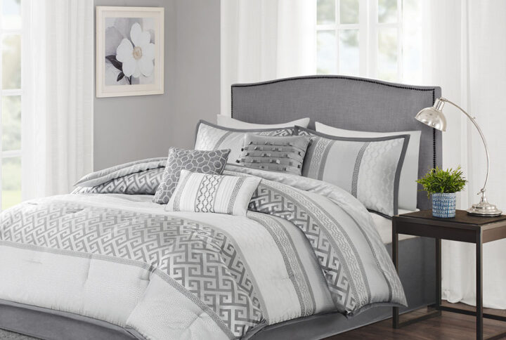 The Madison Park Bennett 7 Piece Jacquard Comforter Set provides an elegant and luxurious update for your bedroom. This jacquard comforter features a striped design with geometric woven motifs to create an updated traditional look. The 2 matching shams repeat a similar striped pattern that pairs perfectly with the comforter. A solid bed skirt made from faux silk and 3 decorative pillows are also included