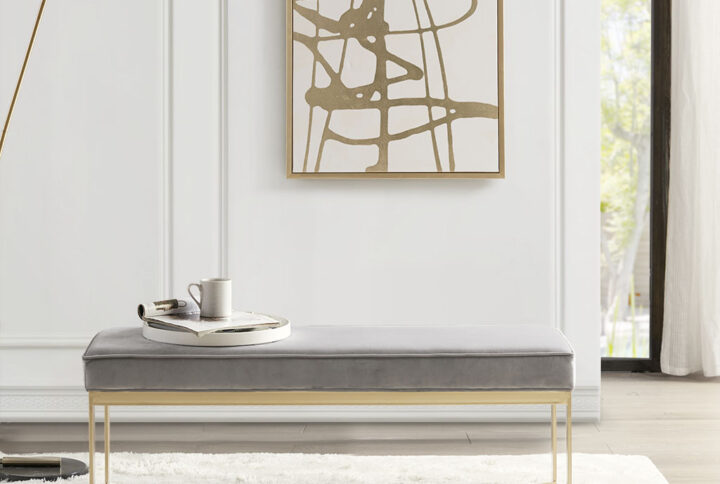 Update your home decor with the sleek style of the Martha Stewart Secor Bench. This accent bench features a grey upholstered seat with a gold metal base that creates a chic modern look. Place this bench in your entryway