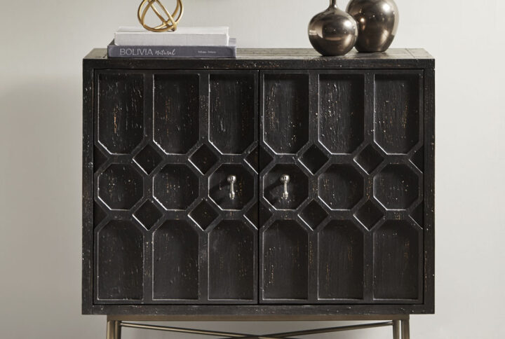 The Madison Park hanley 2 door accent cabinet adds an eye-catching style and functionality to your home decor. This 2-door accent cabinet features a distressed black finish with hand-carved designs on the doors that add charm and dimension. The bronze metal legs provide a sturdy base