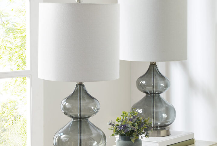 The 510 Design Ellipse Table Lamp Set brings modern elegance to any space. This set of 2 lamps features double-stacked gourd-shaped glass bases with polished surfaces and brushed silver metal accents. The translucent glass softly diffuses light for a warm