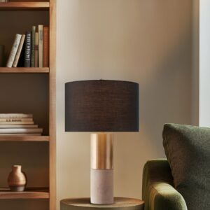 while the sleek gold metal accents add a touch of sophistication. Topped with a black drum shade and secured by a gold metal finial