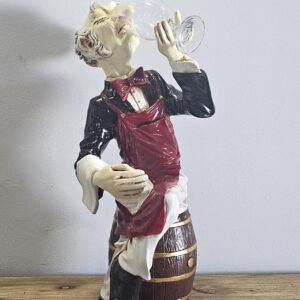We present from Whimsical Treasures an enjoyable multicolored Sitting Connoisseur on Barrel. Featuring elderly wine taster holding one bottle this item brings a unique style. The bar and wine cabinet from the Wine Aficionado Collection will highlight