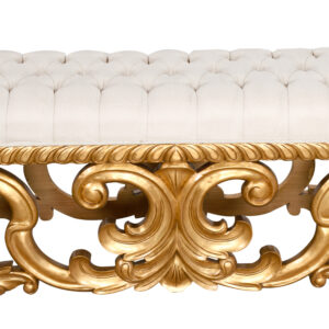 by hand one piece at a time. The frame of the bench is hand carved using kiln dried mahogany wood. It takes expert carvers nearly 30 days to execute the intricate details of the pass through base. Once carved the entire base is gold leafed by hand finishing the stunning base with an exceptional look. The light colored fabric seating compliment the striking and powerful base completing an elegant bench for the right home.