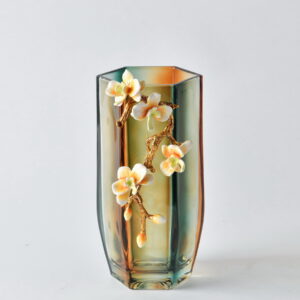 Add a refined touch of nature to your space with the Small Amber Bloom Hexagonal Vase. Featuring a sculptural orchid branch in gleaming gold with soft peach blossoms