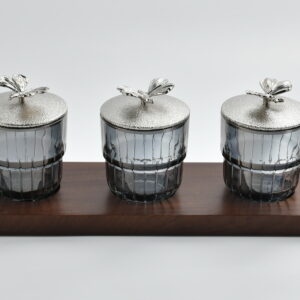 each crowned with a textured silver lid adorned by a delicate monarch butterfly finial. The smoke tinted glass adds a modern edge