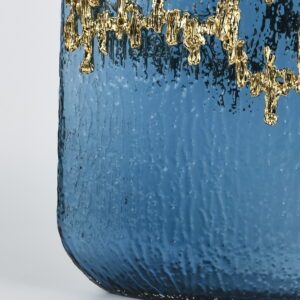 this cylindrical vase is crowned with a dramatic cascade of molten gold detailing that shimmers like liquid metal. Perfect for elevating floral arrangements or standing alone as a sculptural showpiece. Turn any room into a gallery of style with this high-impact vase that blends glamor